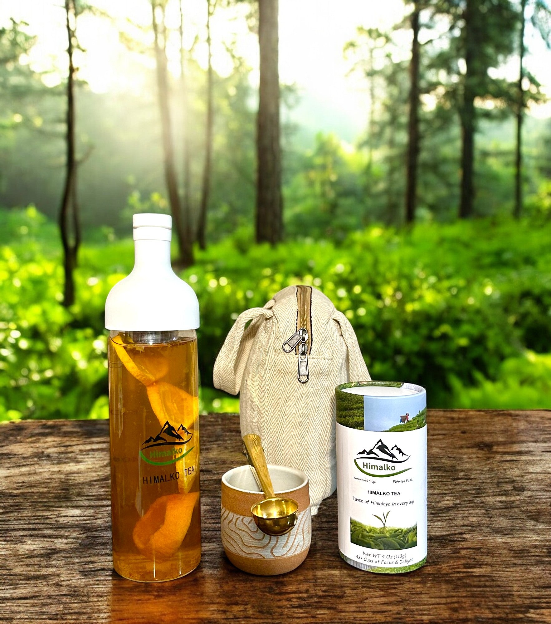 A tea gift set displayed outdoors, including a cold brew bottle, a handcrafted stoneware teacup, a tea scoop, and a gift bag.