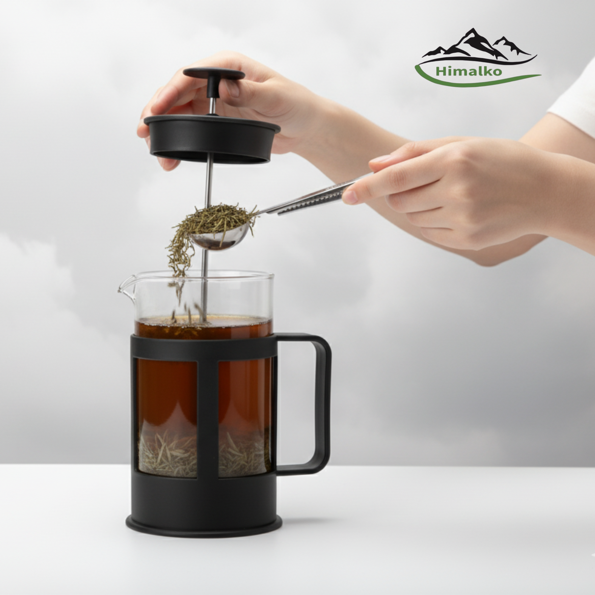 Person using a tea infuser with a glass mug on a white background, featuring the Himalko brand logo.