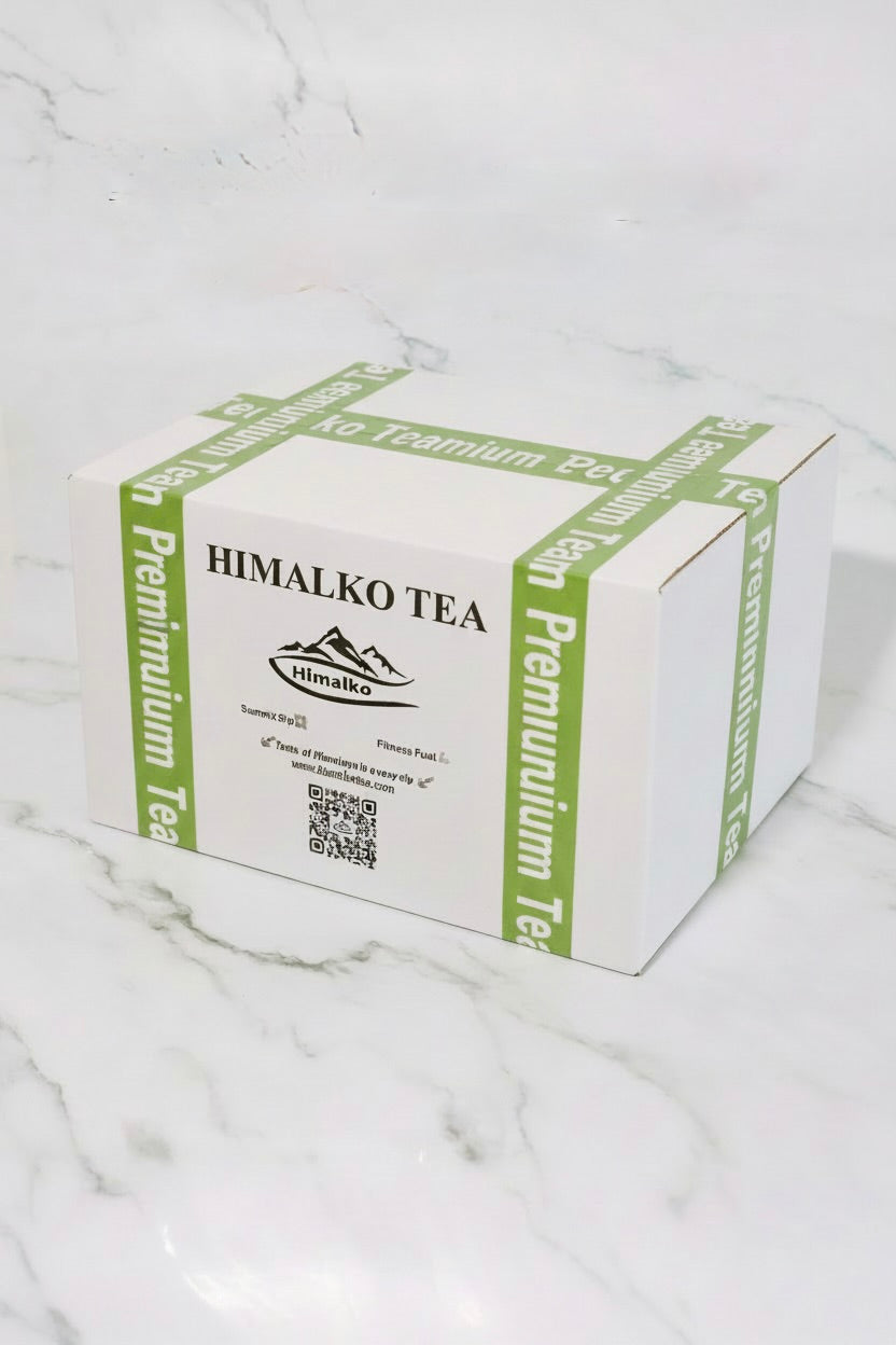 A white cardboard box of Himalko Premium Tea with green printed text and branding, placed on a white marble surface.