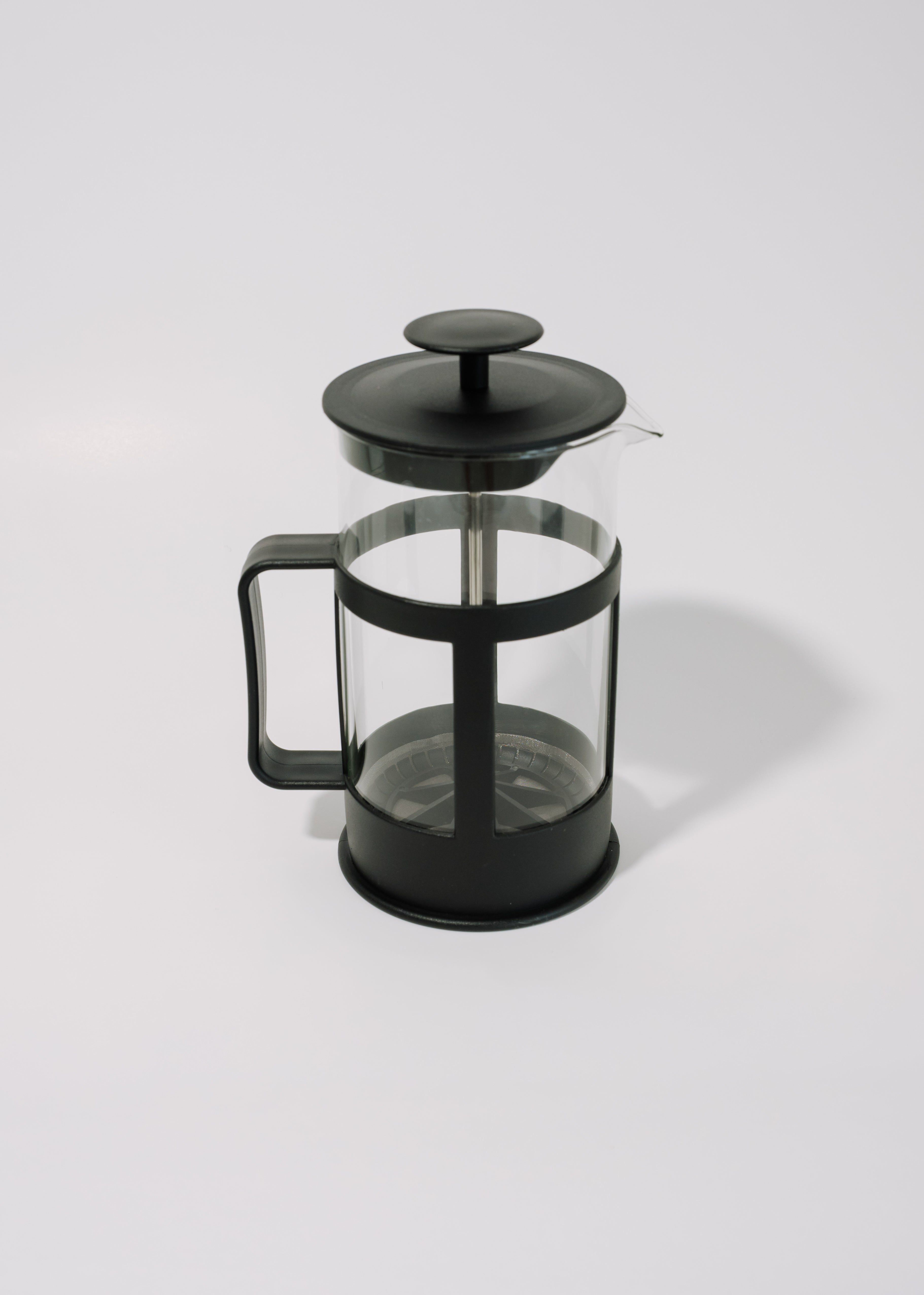 A classic French press coffee maker with a black plastic handle and lid, a clear glass body, and a black metal plunger, shown on a light gray background.
