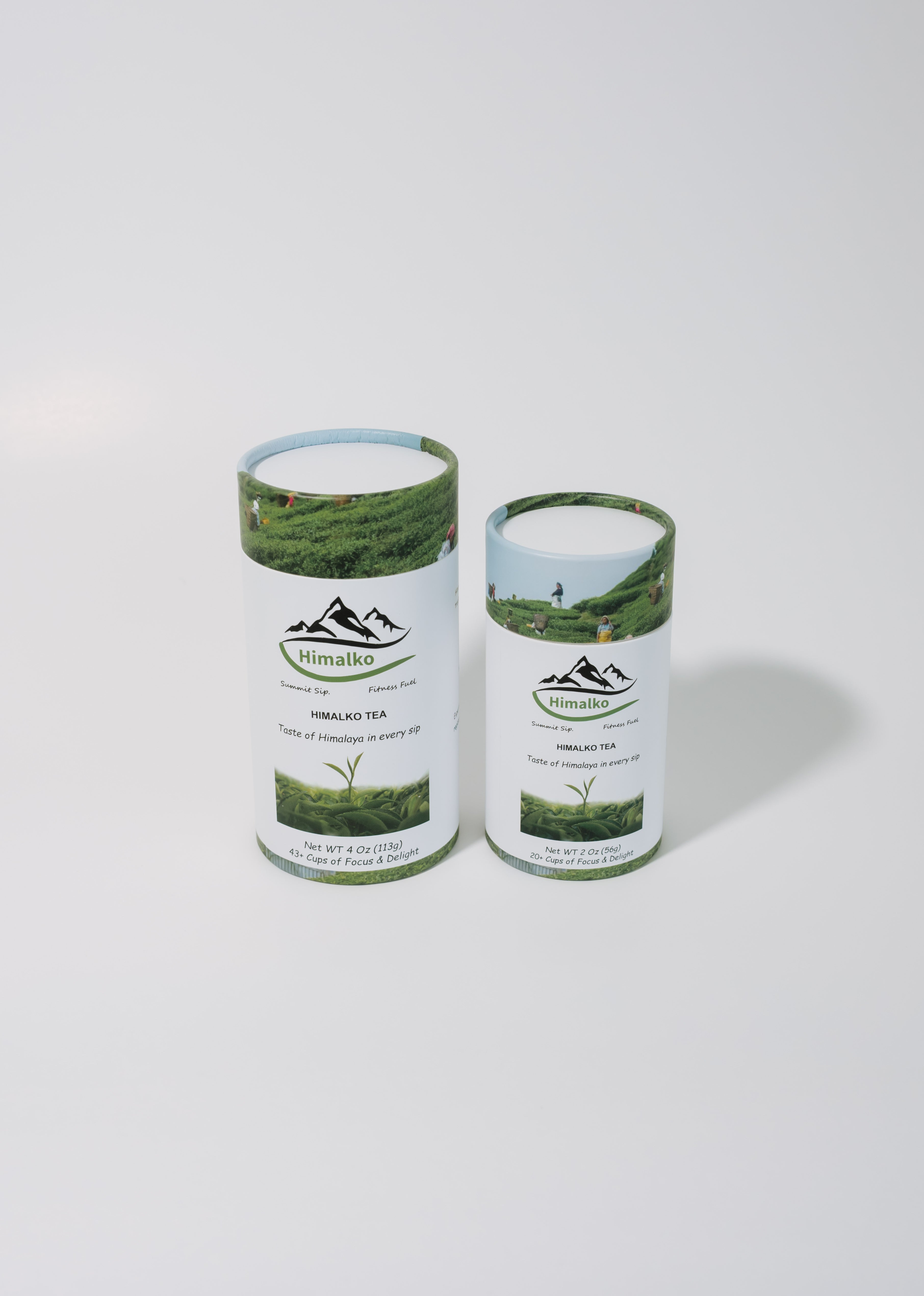 Two cylindrical metal tea cans with white labels featuring green mountain and tea plant graphics, labeled Himalai Tea, on a light gray background.