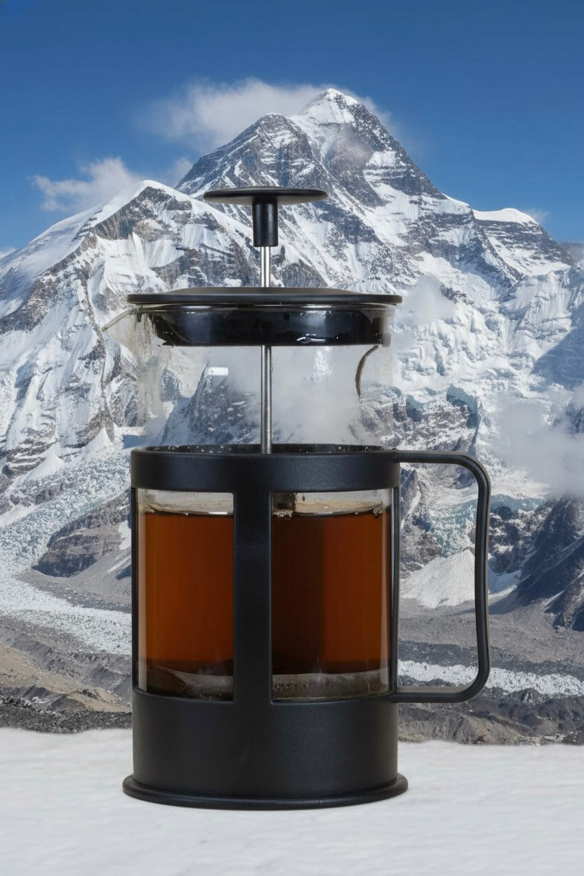 French press with coffee against a mountainous background